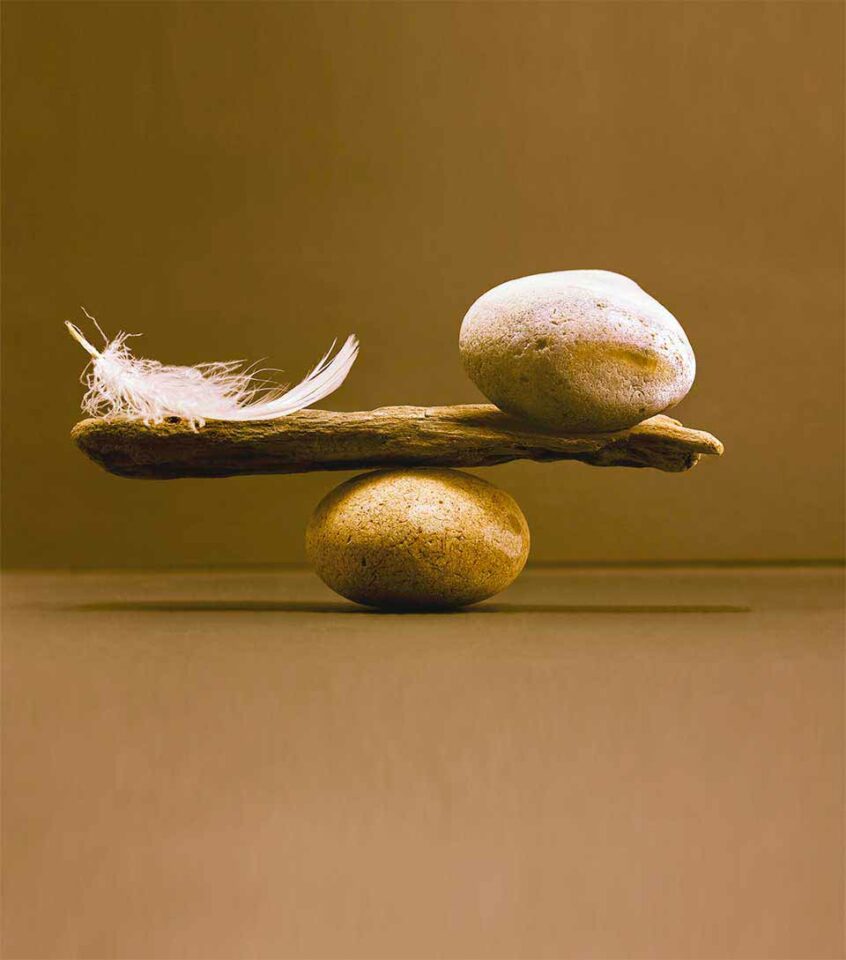 Waage aus Steinen Feder und Stein im Gleichgewicht